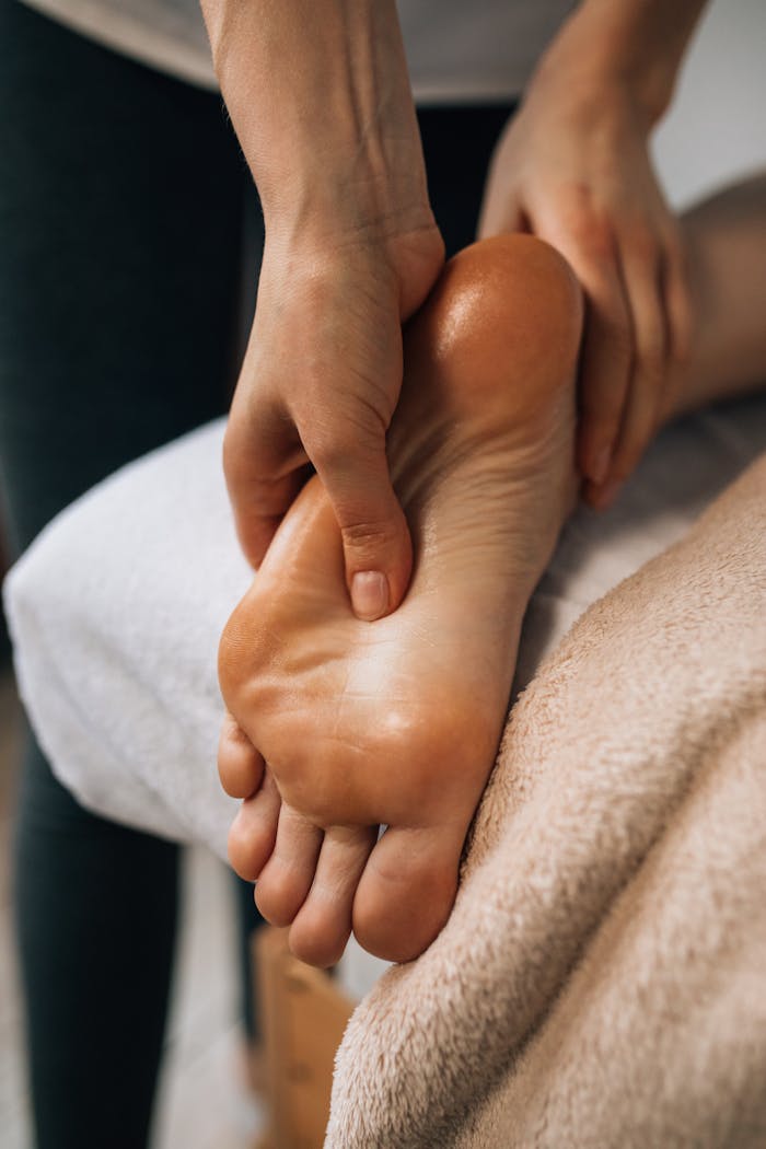 why-choose-us Hands massaging a foot to provide relaxation and promote wellness indoors.